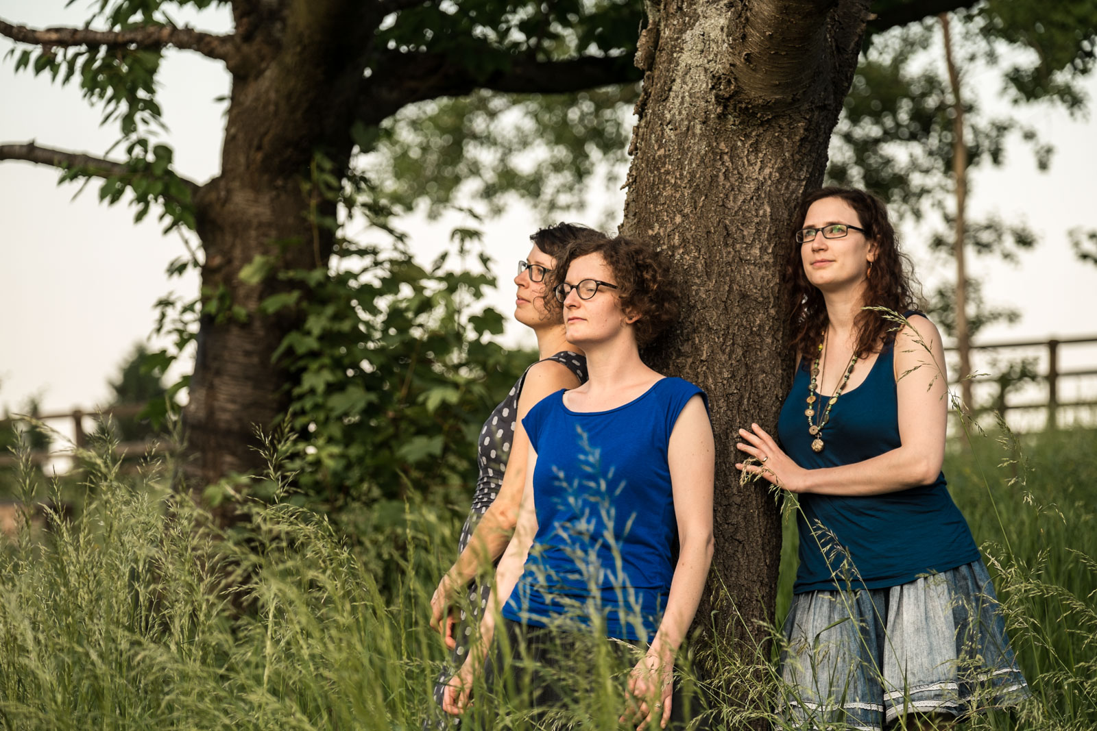 Drei Frauen schauen in die Sonne während sie unter einem Baum stehen